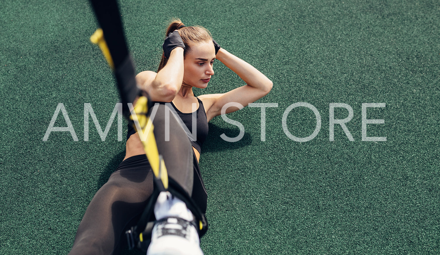 High angle view of woman athlete doing abdominal exercises using suspension straps	
