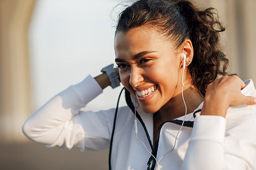 Portrait of a young woman wearing a hoodie and smiling after a workout