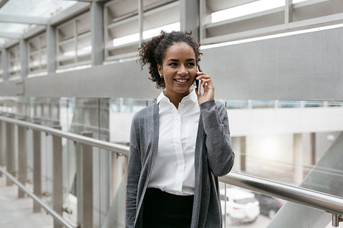 Happy businesswoman talking on cellphone from airport