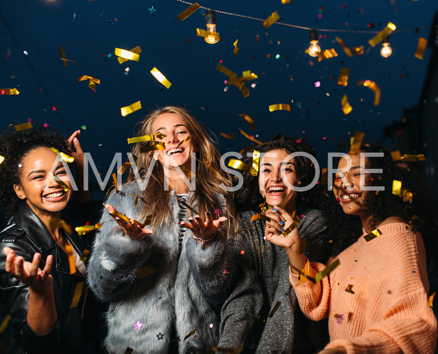 Group of four diverse friends laughing and having fun at night 