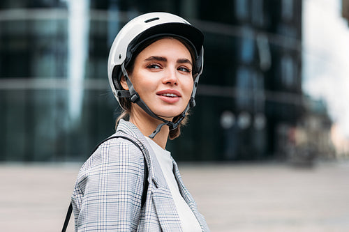 Portrait of a young businesswoman in cycling helmet standing in the city