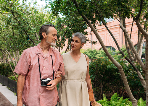 Senior couple walking in the park together. Aged tourists walking outdoors.