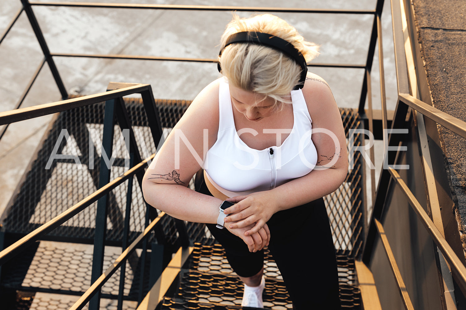 High angle view of a plus size woman standing on a staircase