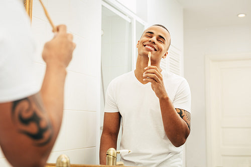 Happy man with bamboo brush in bathroom