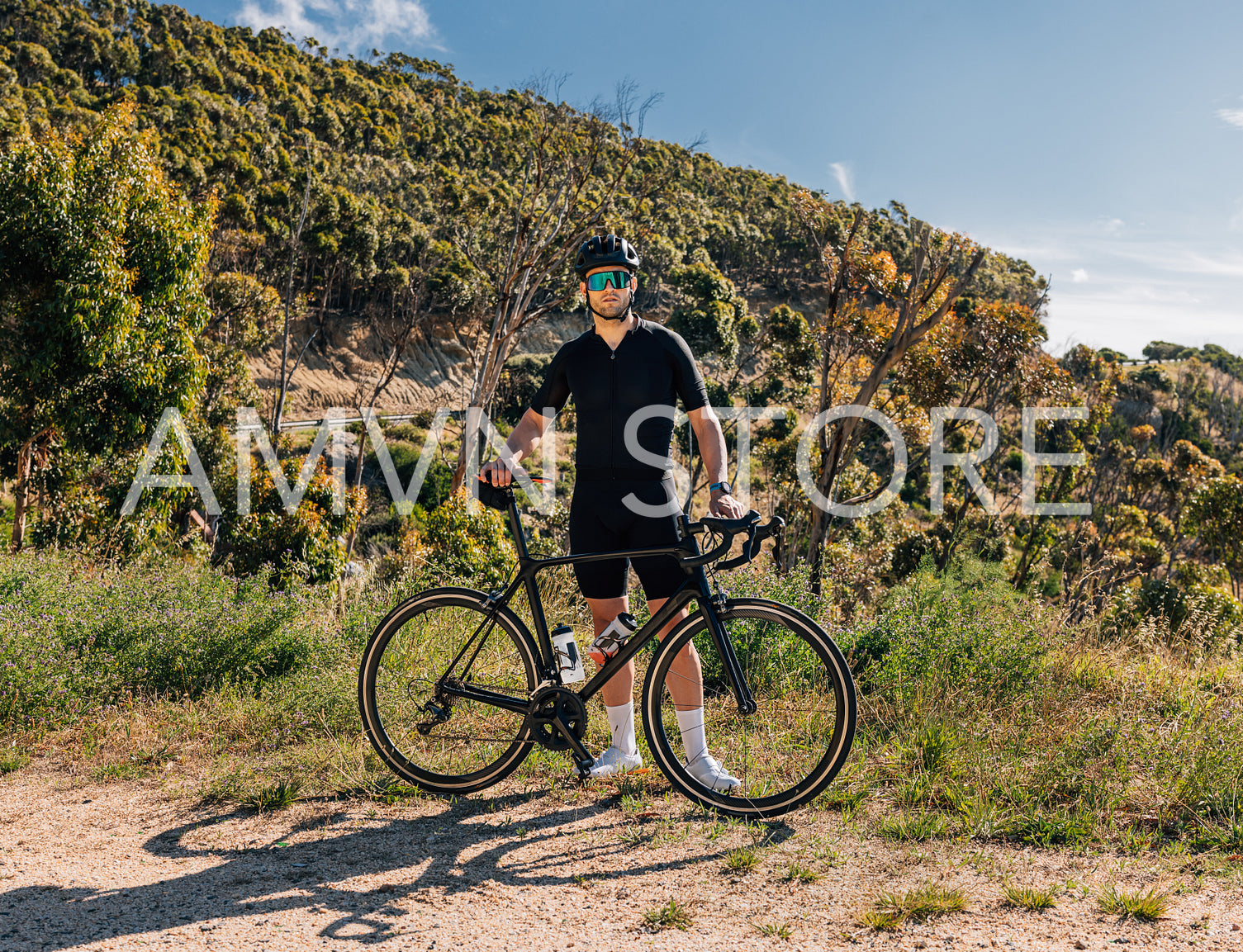 Sportsman in black fitness attire relaxing in wild terrain after a bicycle ride