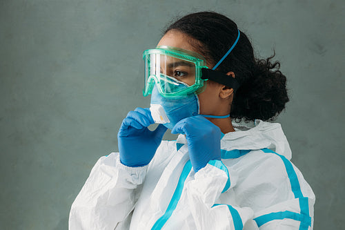 Young woman wearing a protective mask preparing for work