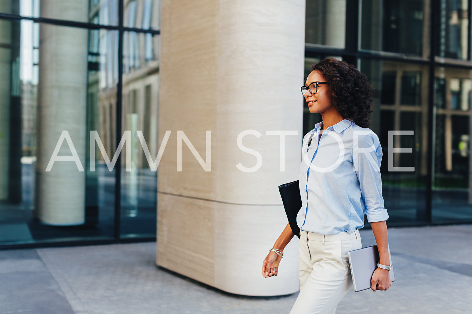 Business professional outside an office building, walking with digital tablet in her hand	