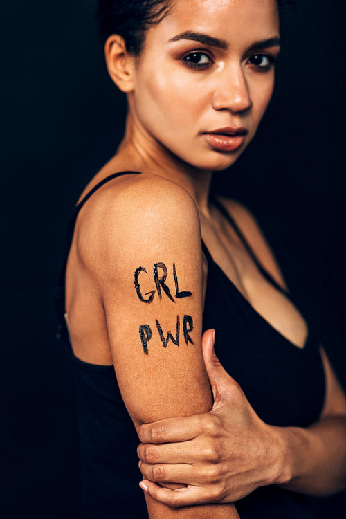 Serious woman with letters "GRL PWR" on her hand