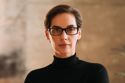 Portrait of an adult businesswoman in eyeglasses.  Confident woman working in CEO position in a company looking at camera.