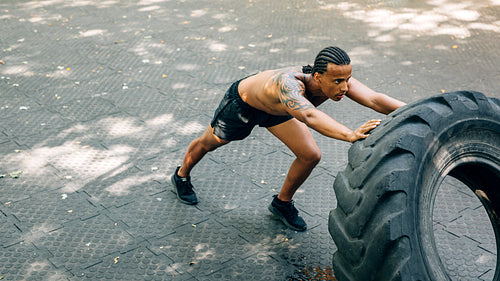 Man working out with heavy tire outdoors