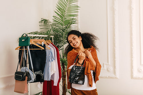 Smiling buyer with eyes closed standing at wardrobe