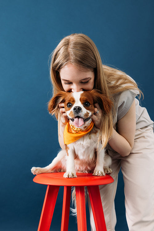 Close up portrait of a young woman and her little dog in studio