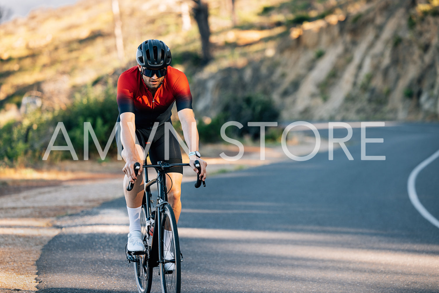 Cyclist in a helmet and glasses rides a bike down the road