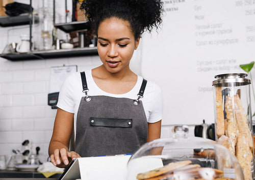 Waitress using a digital tablet at a table in coffee shop