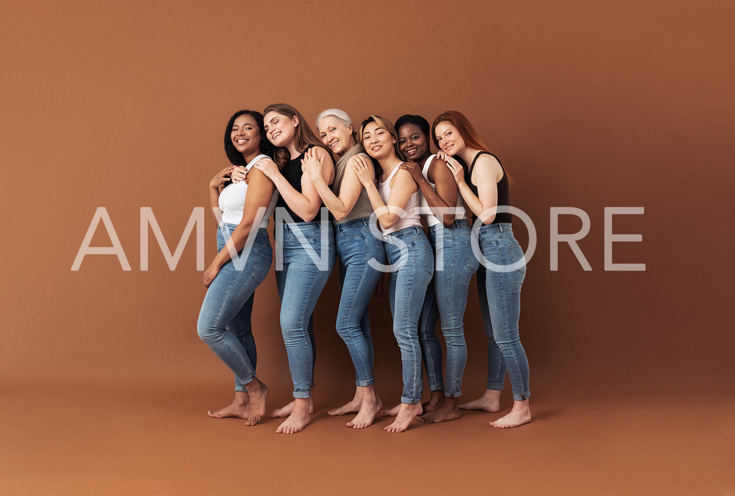 Full length of six smiling women embracing in studio. Females of different ages and body types posing over brown background.