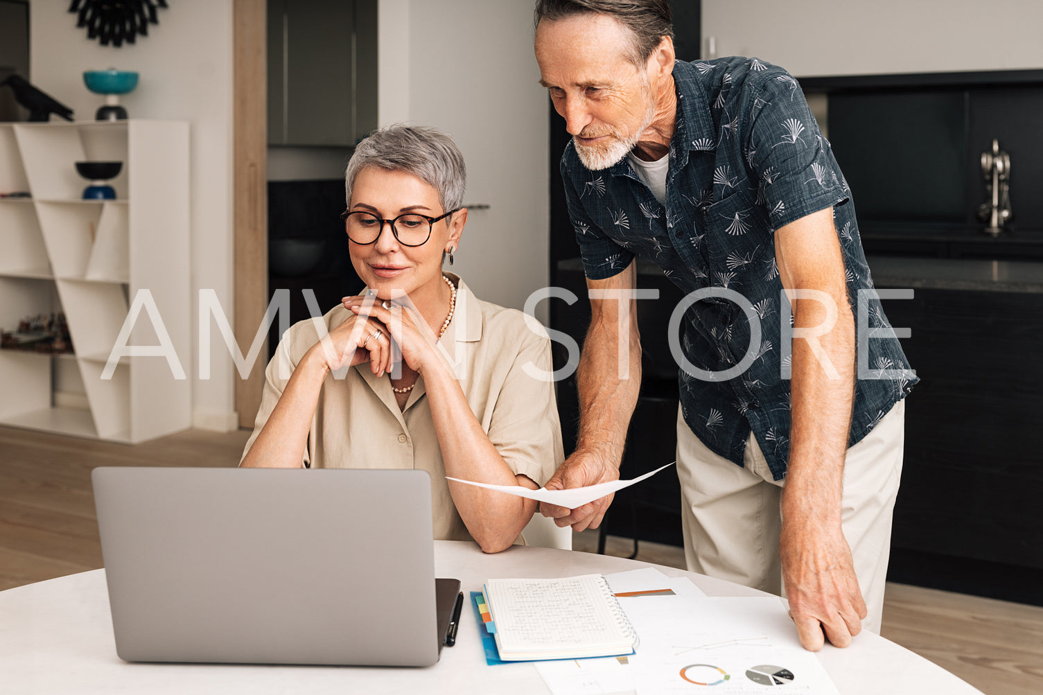 Senior caucasian couple calculating bills at home. Two mature people looking at laptop and managing finances.