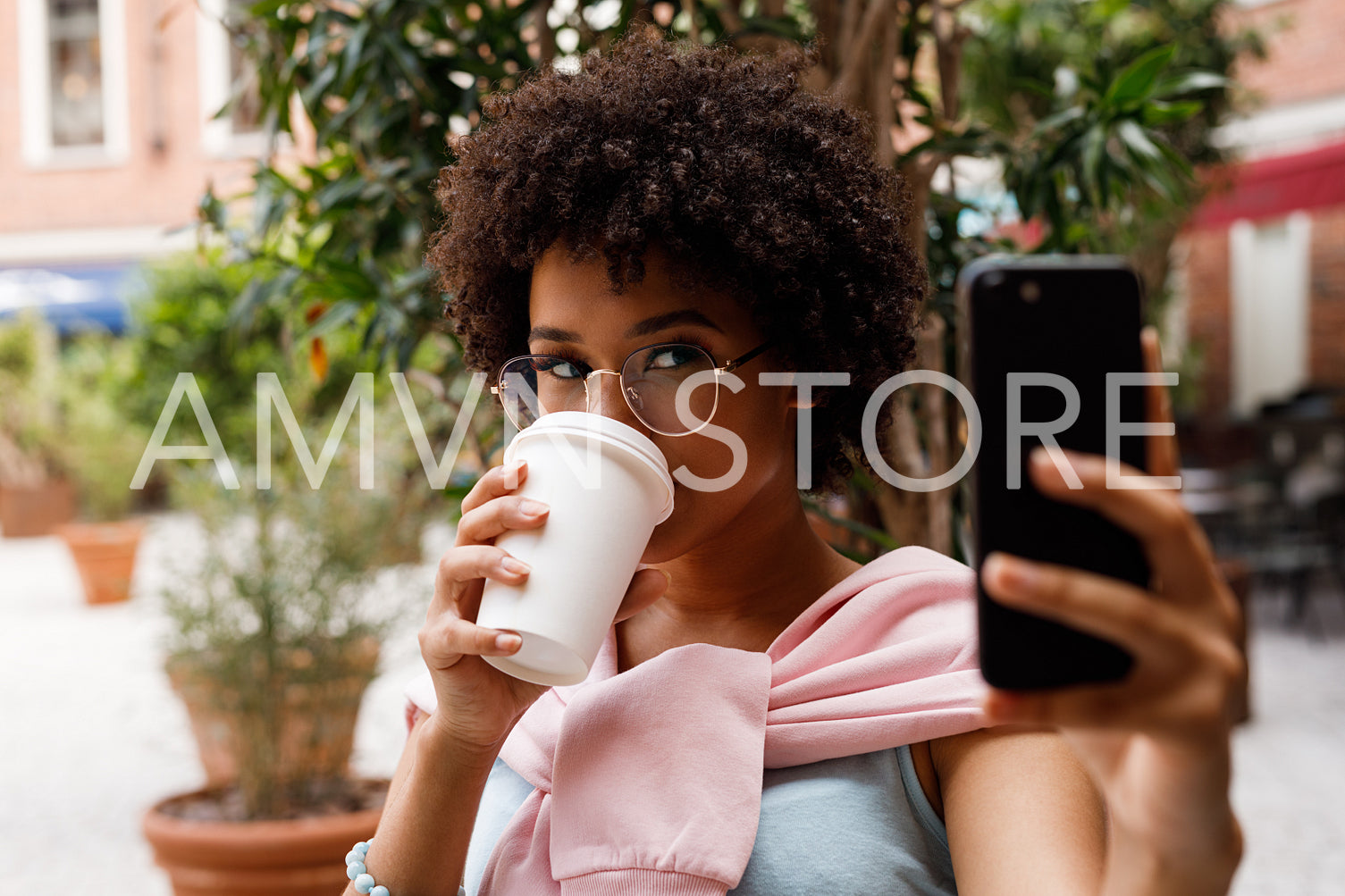 Female blogger taking a selfie on smartphone while drincking a coffee	