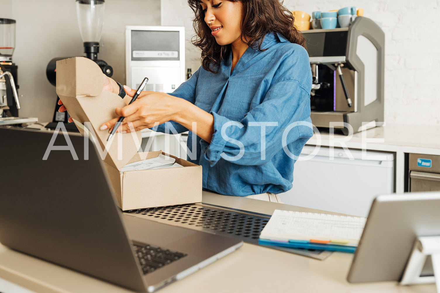 Small business owner closing a cardboard box finishing packing an online order	