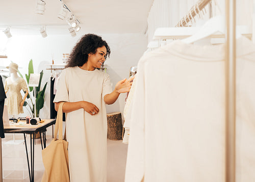 Side view of a fashionable woman looking for new clothes in smal