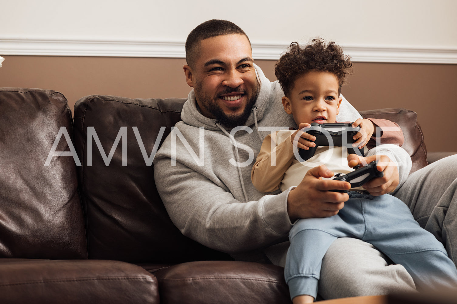 Excited father and son playing video game on a console at home