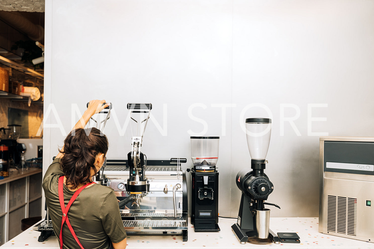 Rear view of barista using coffee maker in coffee shop	