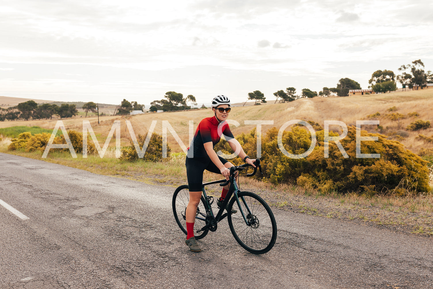 Full length of a pro cyclist taking a break from intense training on country road