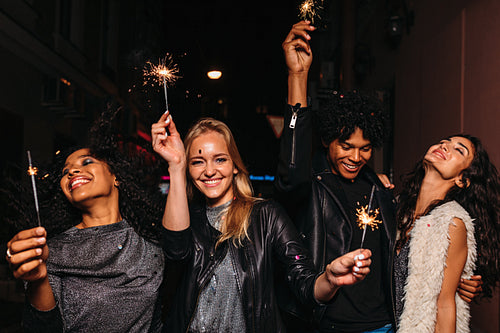 Four diverse friends having fun on night street