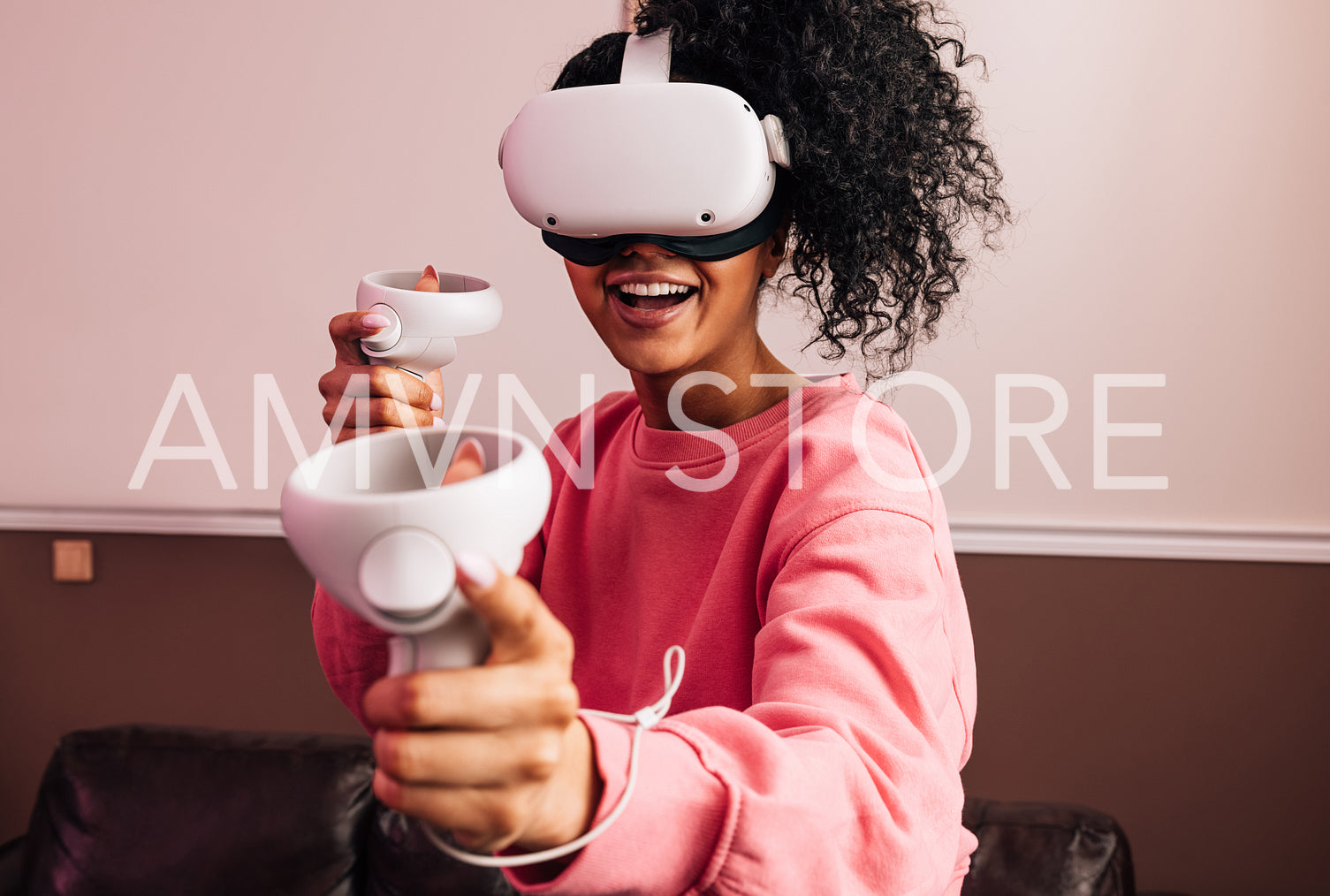 Young smiling woman using VR set while standing in living room. Female in casuals having fun with virtual reality games.