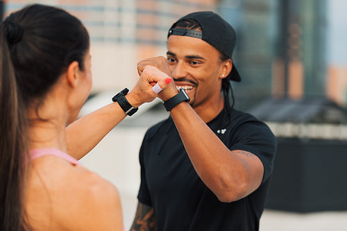 Fitness couple giving fist bump after training on the roof