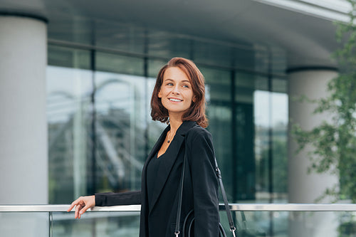 Smiling businesswoman with ginger hair looking away while standing outdoors