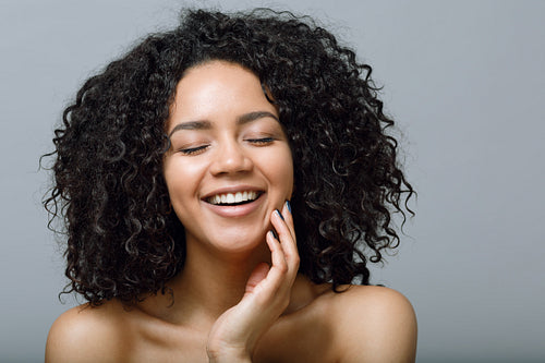 Portrait of a woman with curly hair and closed eyes, studio shot