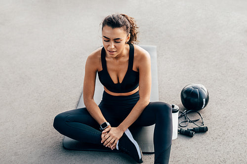 Exhausted woman resting after an intense workout on a mat with closed eyes