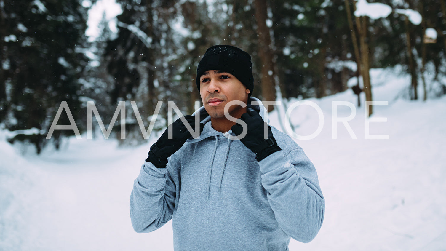 Male runner holding hood, resting after training outdoors	