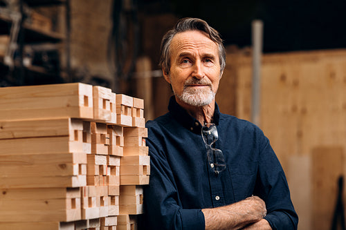 Portrait of confident senior male carpenter standing in his workshop