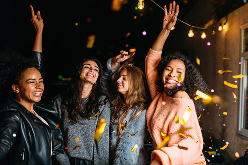 Group of girls dancing at night outdoors. Friends having good times together.