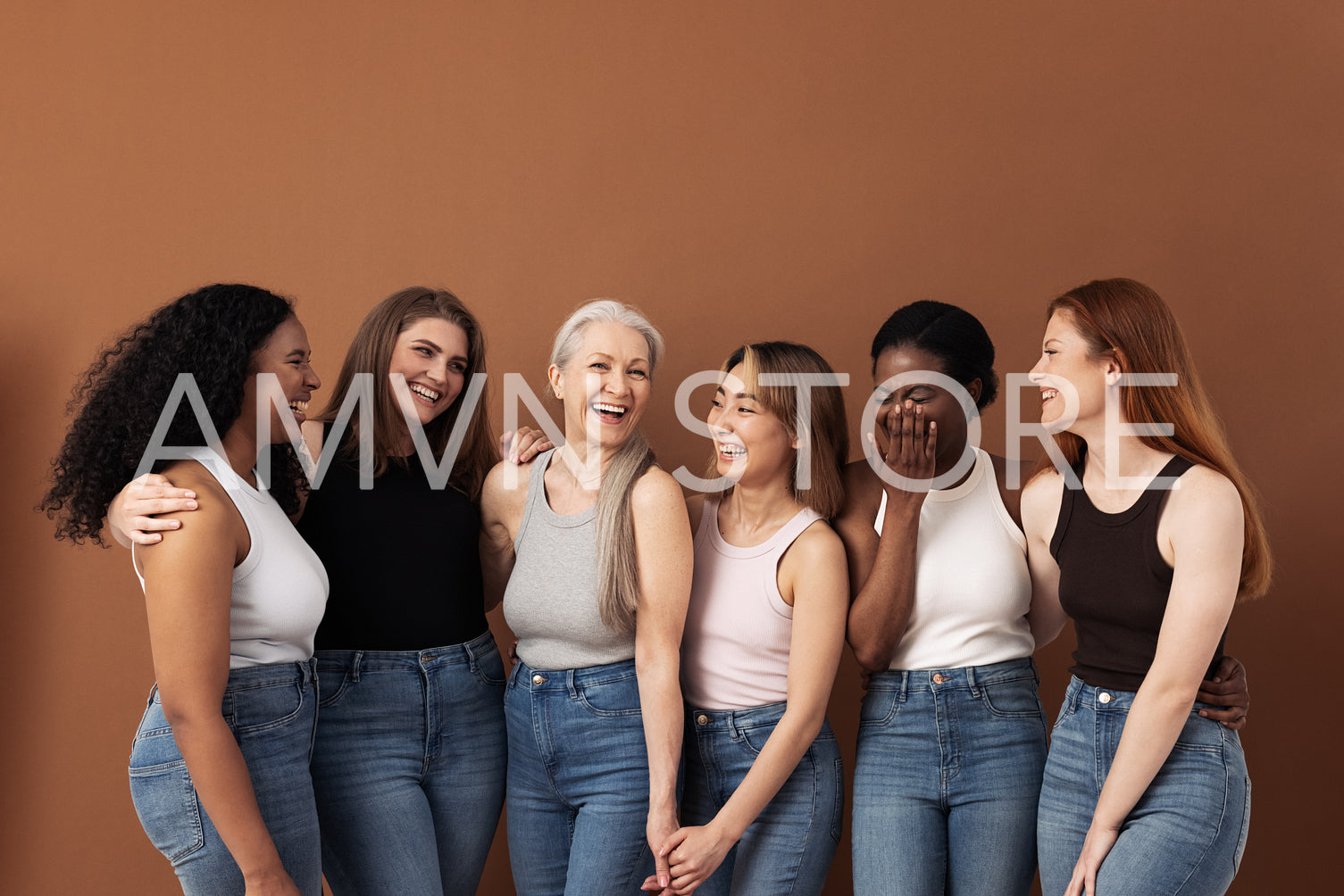 Stylish women of different ages having fun while wearing jeans and undershirts over brown background