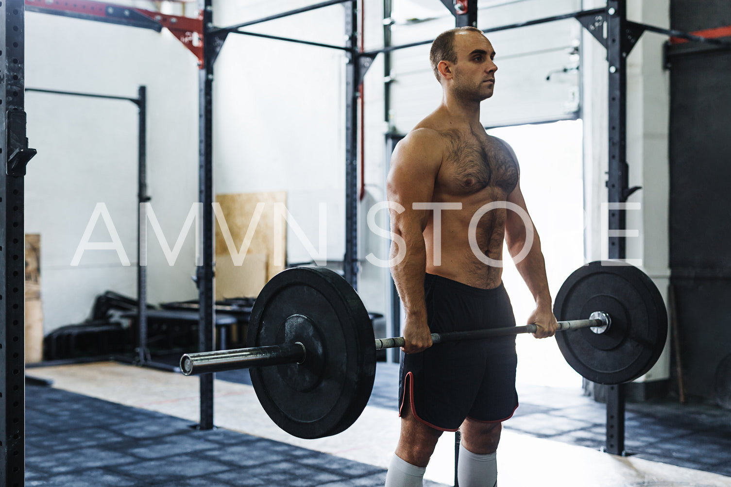 Strong young man exercising with heavy weights at gym	