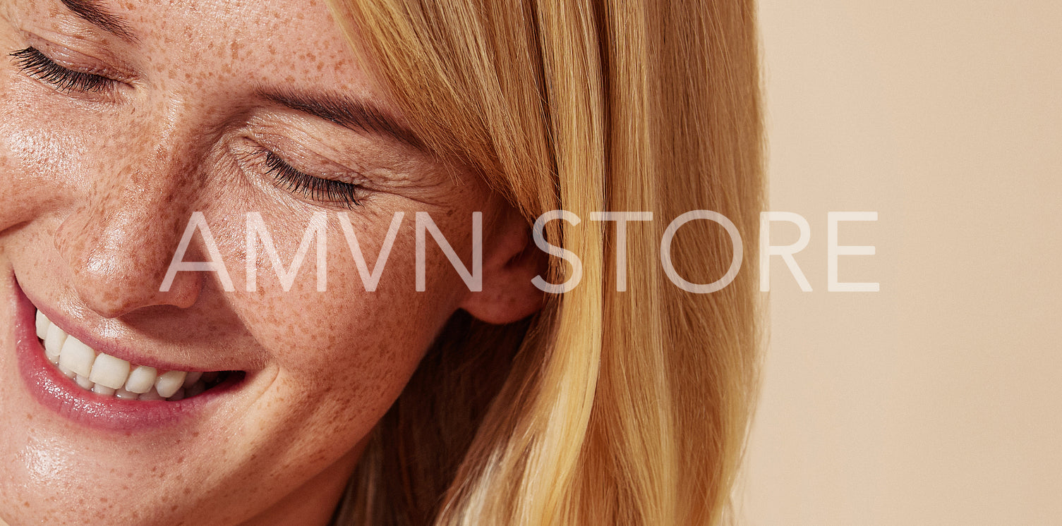 Close-up high detailed cropped shot of a smiling blonde woman with freckled skin