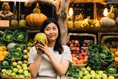 Asian woman holding a melon