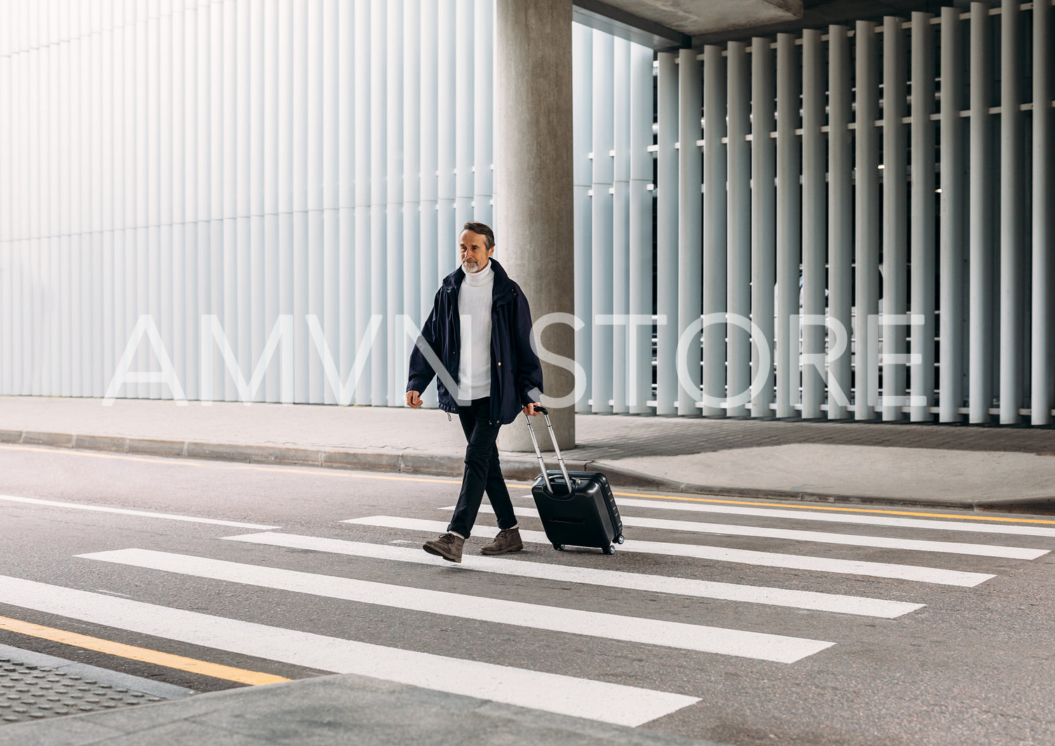 Senior man walking outside public transport building with suitcase	