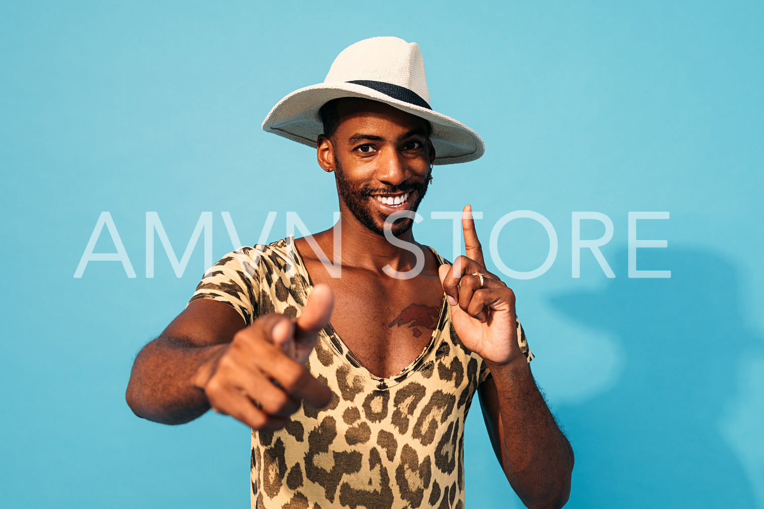 Young cheerful man dancing in studio and looking at camera