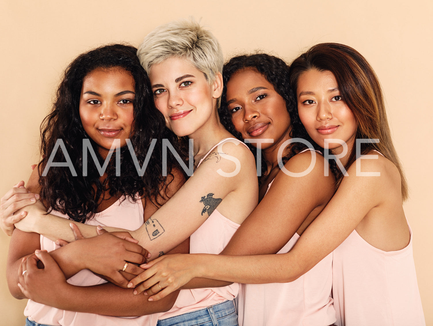 Studio shot of a group of beautiful young women hugging each other	