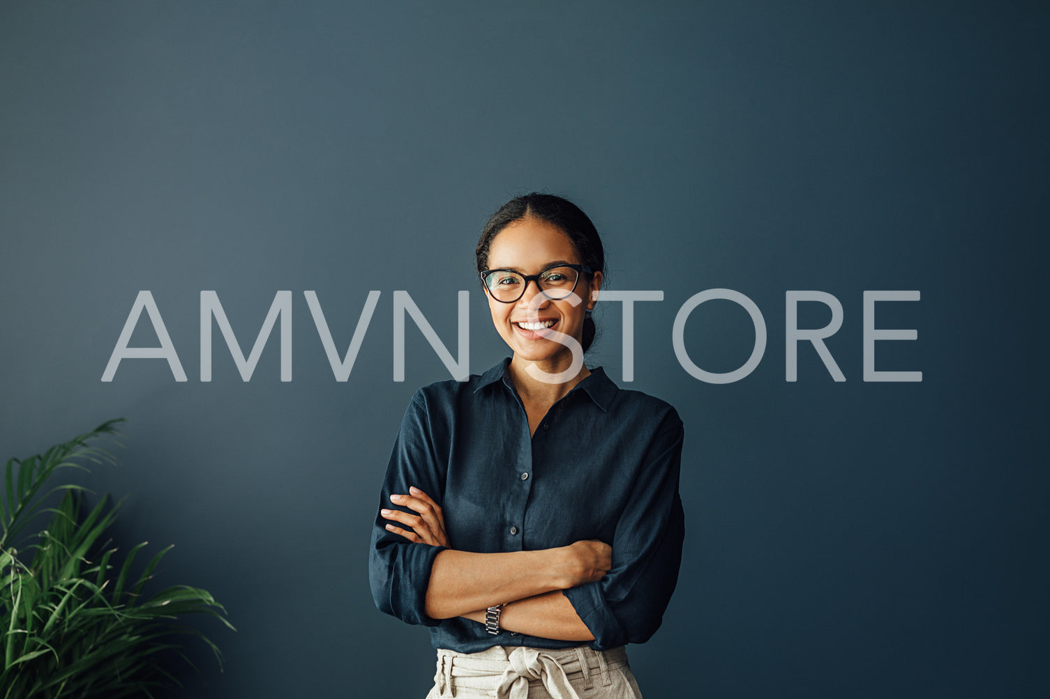 Portrait of a beautiful smiling businesswoman standing with crossed arms in living room	