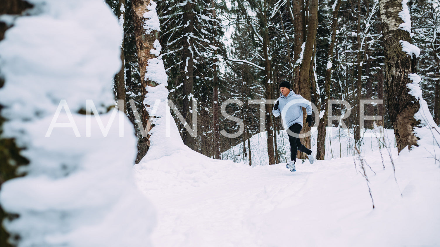 Young healthy man running in forest at winter	
