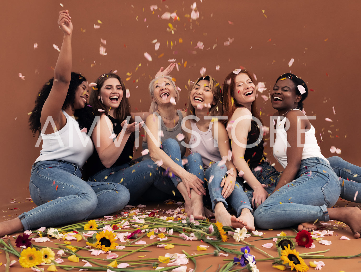 Multi ethnic group of happy women sitting under falling petals