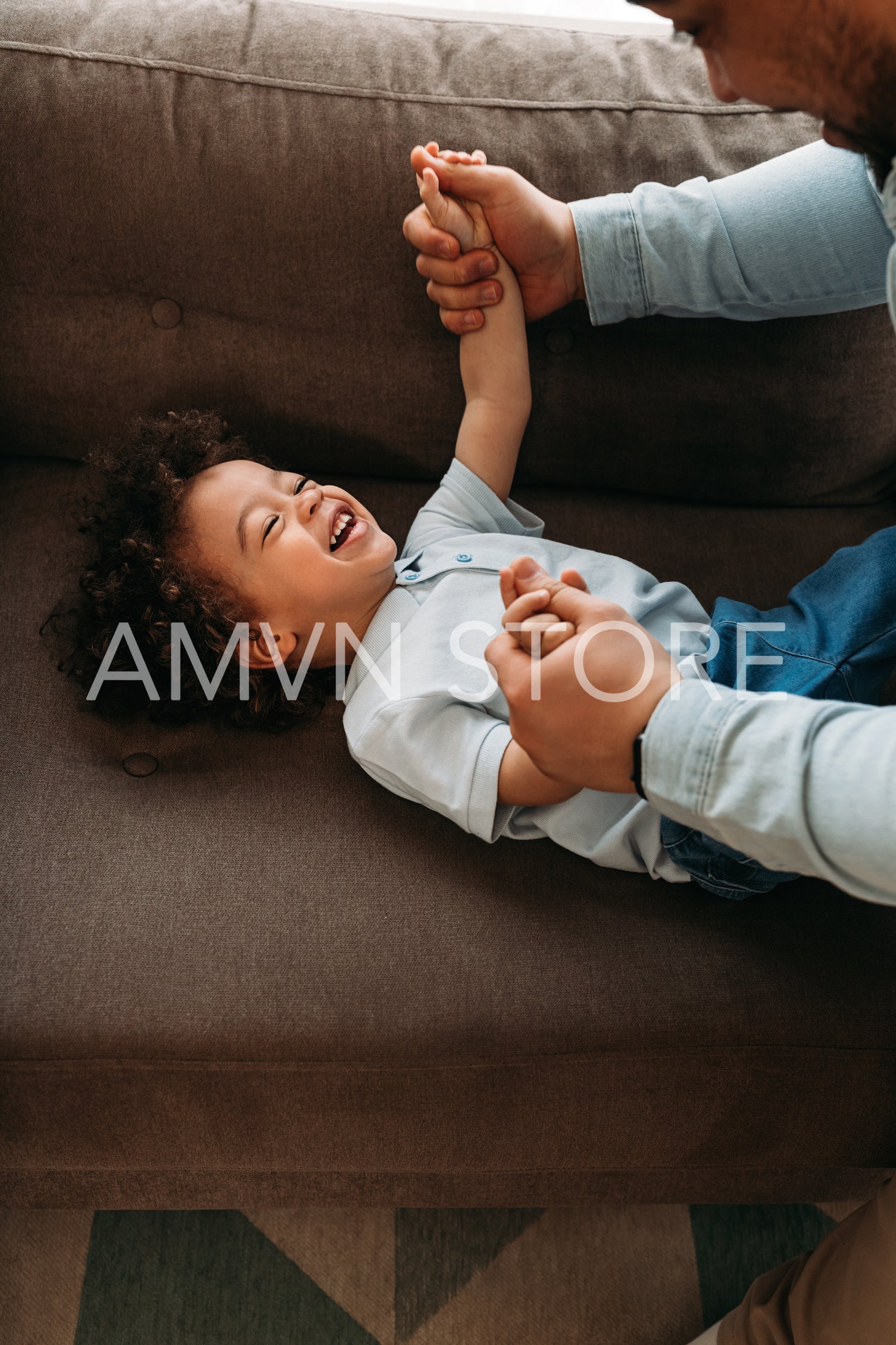 Happy little boy playing with his dad in living room