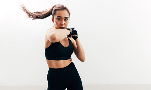 Woman doing shadow boxing. Female athlete wearing gloves.