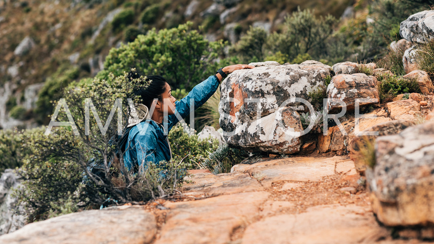 Side view of woman hiker climbing up on a mountain