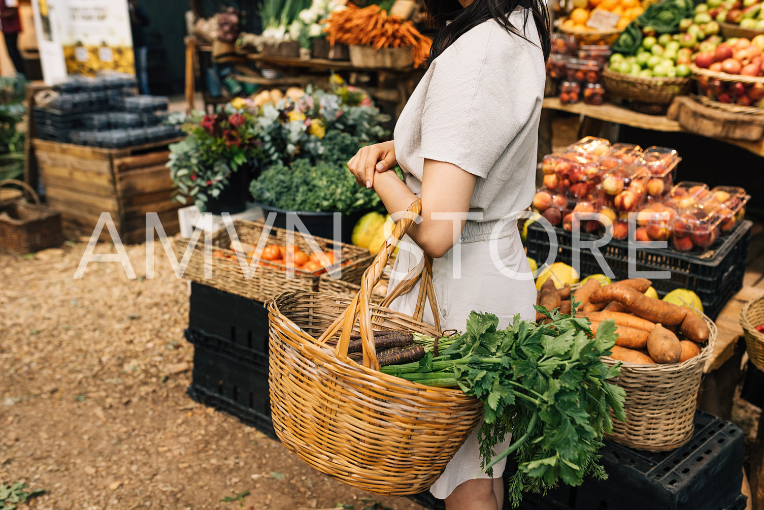 Woman with a basket in her hand at an outdoor market. Unrecognizable female looking for organic food on local farmer market.