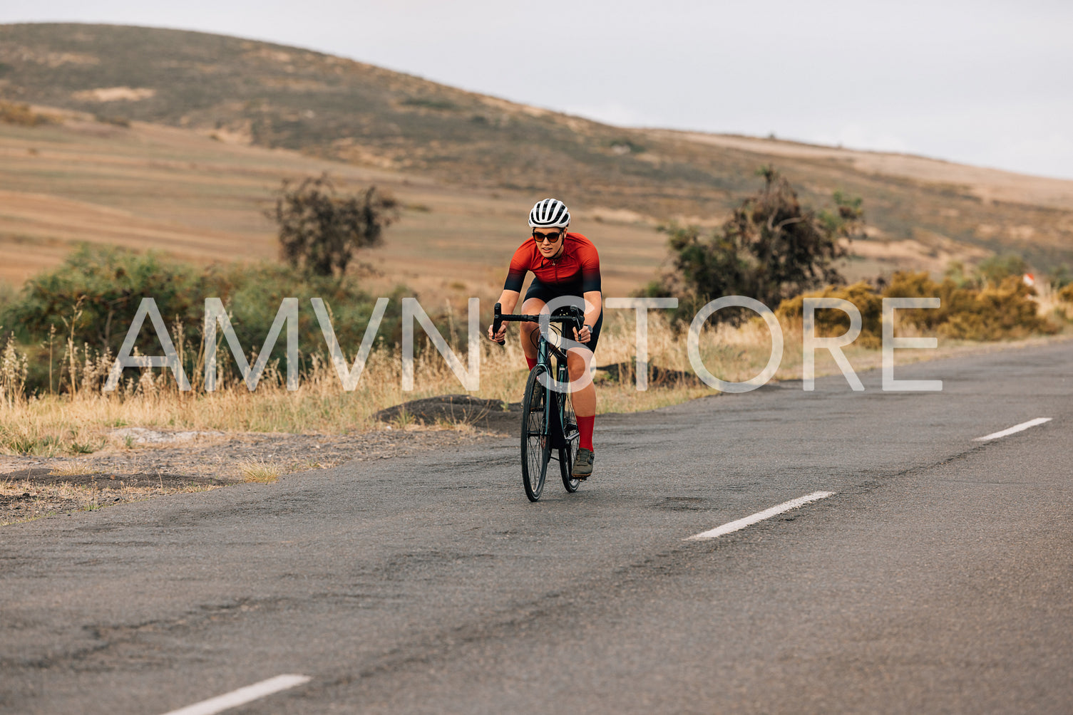 Young woman riding a bike on countryside road